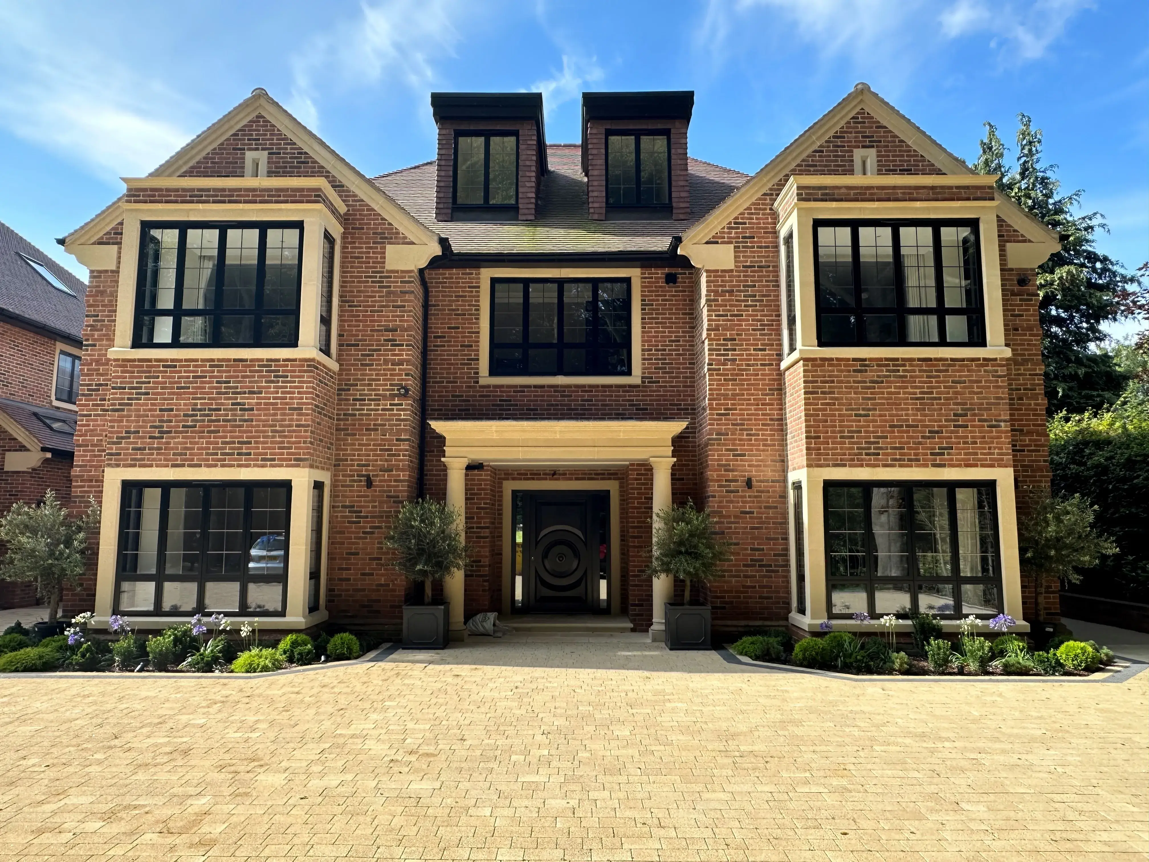 A large brick house with a clock on the front of it.